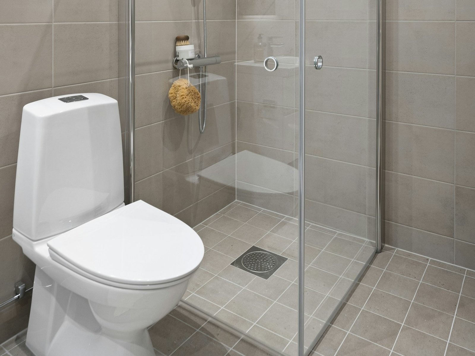 Nasse Haare liegen auf einem Duschabfluss im Badezimmer