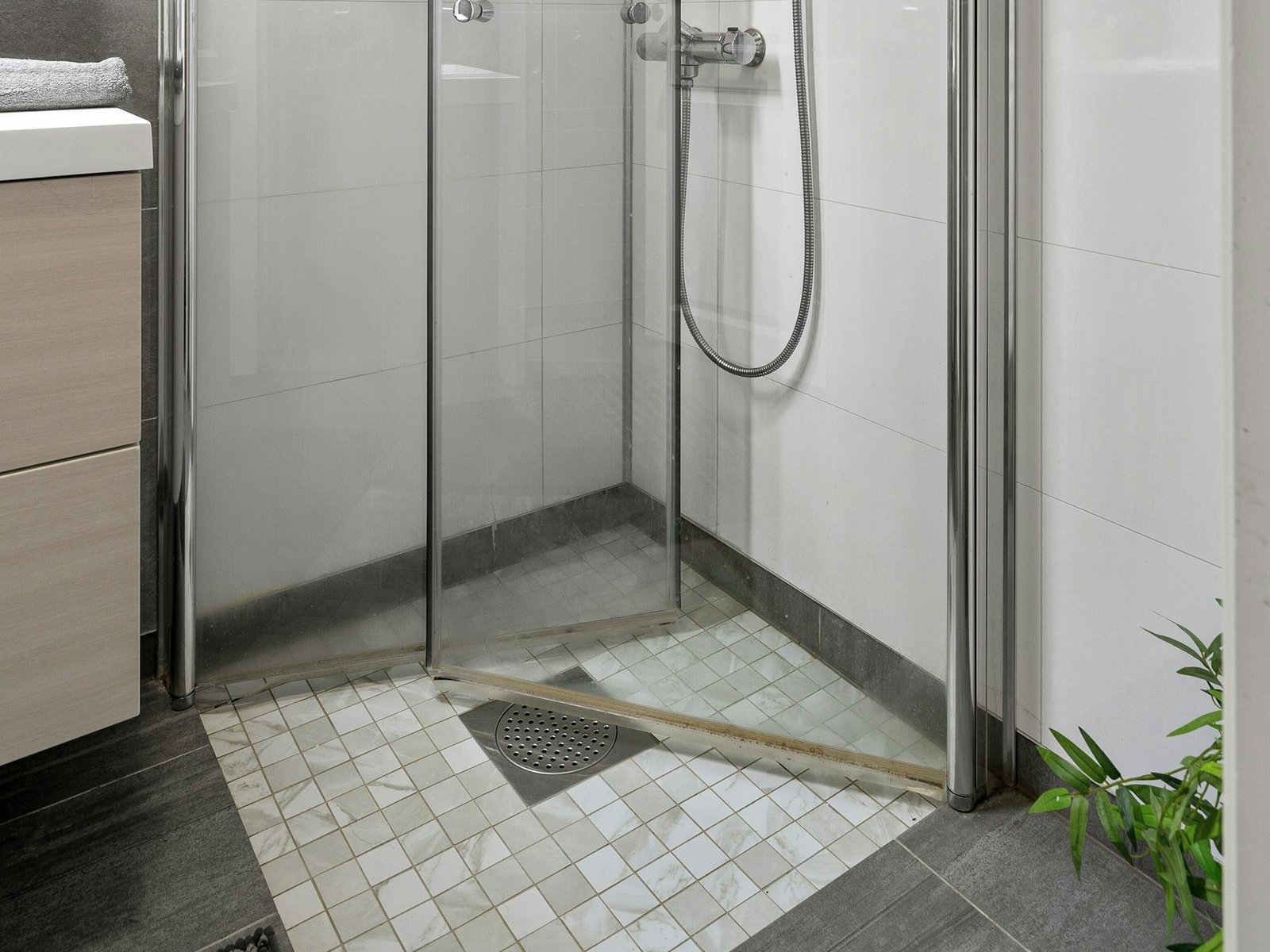 Haare liegen auf einem Duschabfluss aus Metall